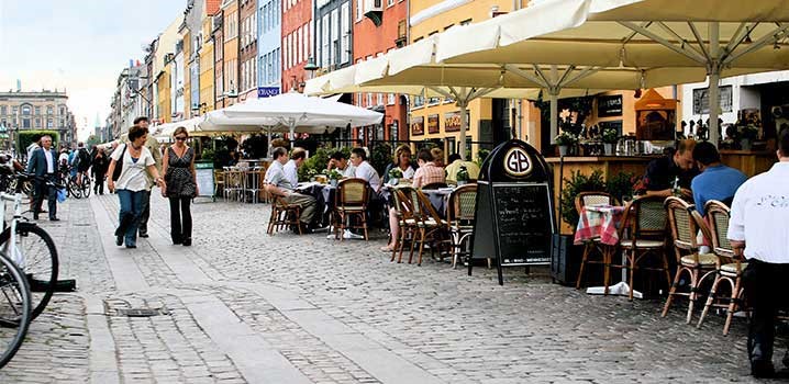 Mennesker på udendørsterrasse ved en lystbådehavn