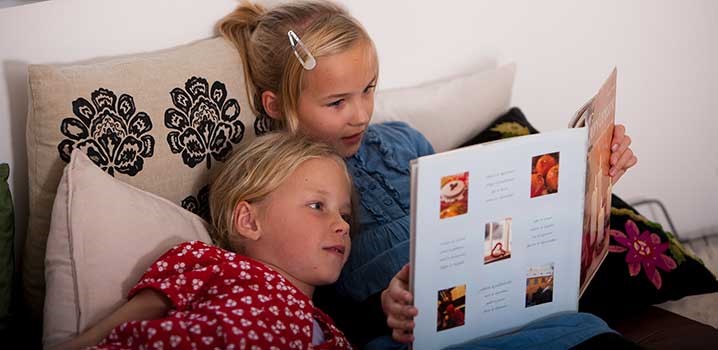 To piger hygger og læser bog sammen